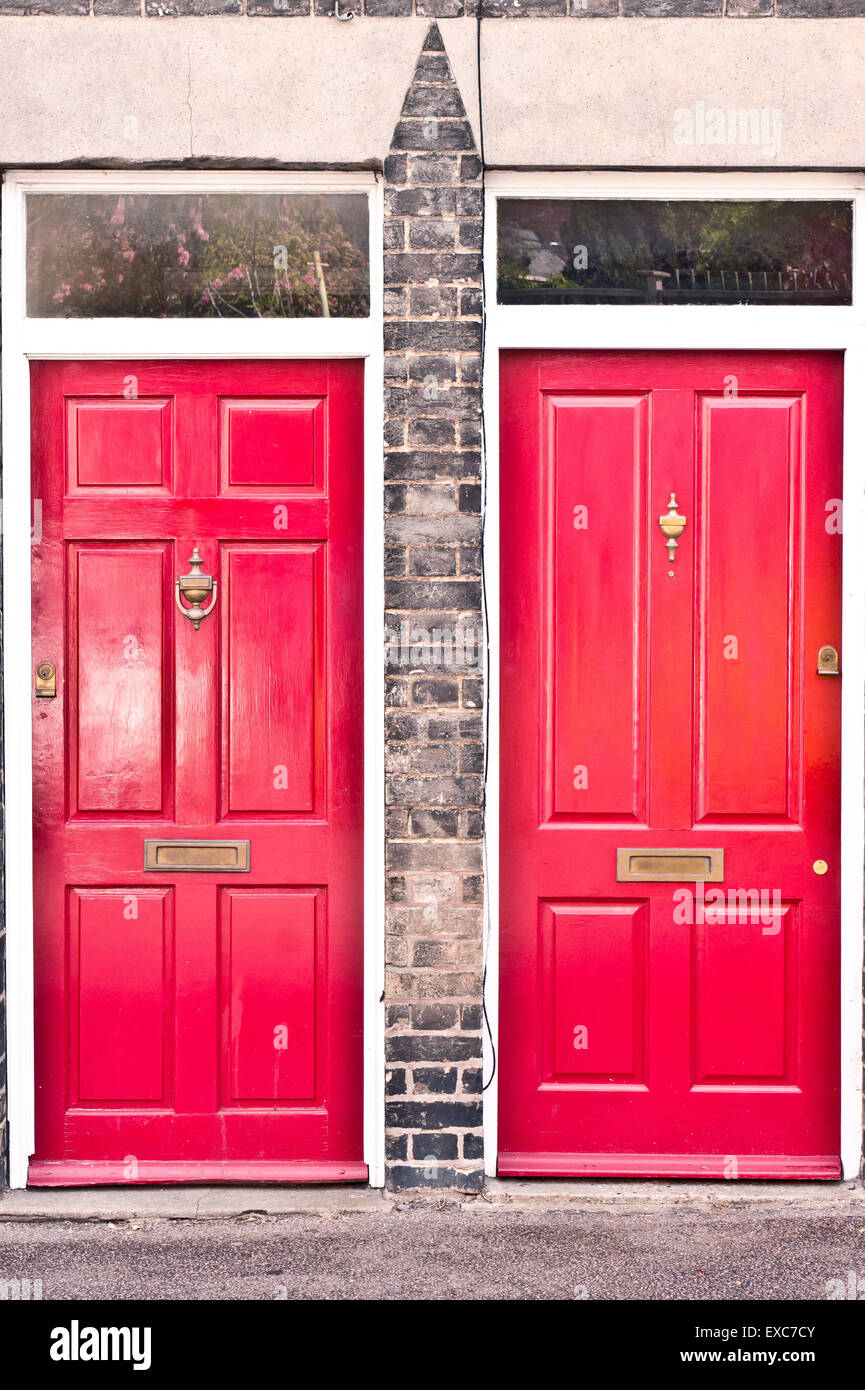 Benachbarte rote Front Holztüren in benachbarten Häusern in Großbritannien Stockfoto