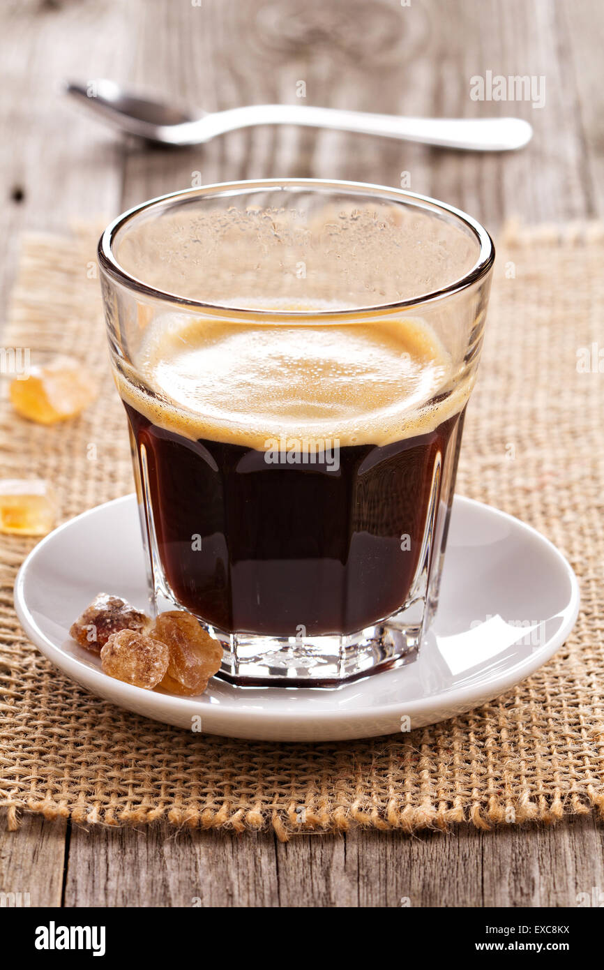 Schwarzer Kaffee im Glas mit Kristallzucker Stockfoto