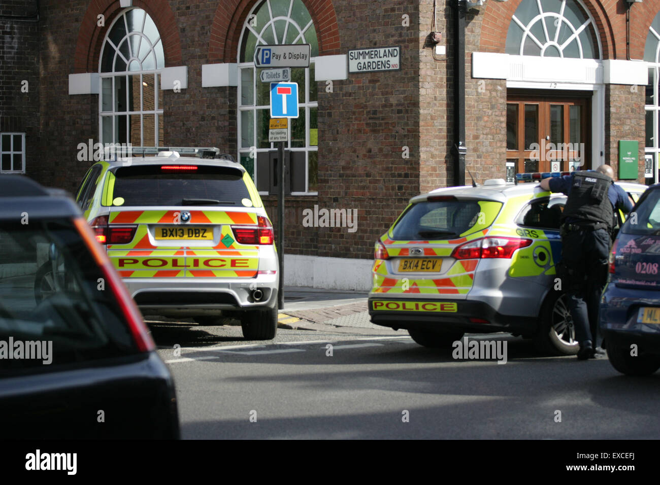 Muswell Hill, London, Großbritannien. 11. Juni 2015,-Polizei, einschließlich der zugelassenen Waffen Offiziere, besuchen einen Vorfall bei einer Filiale der Lloyds Bank in Muswell Hill im Norden Londons. Ein Mann in Handschellen galt in der Rückseite eines Polizeiautos Credit: Finn Nocher/Alamy Live News Stockfoto