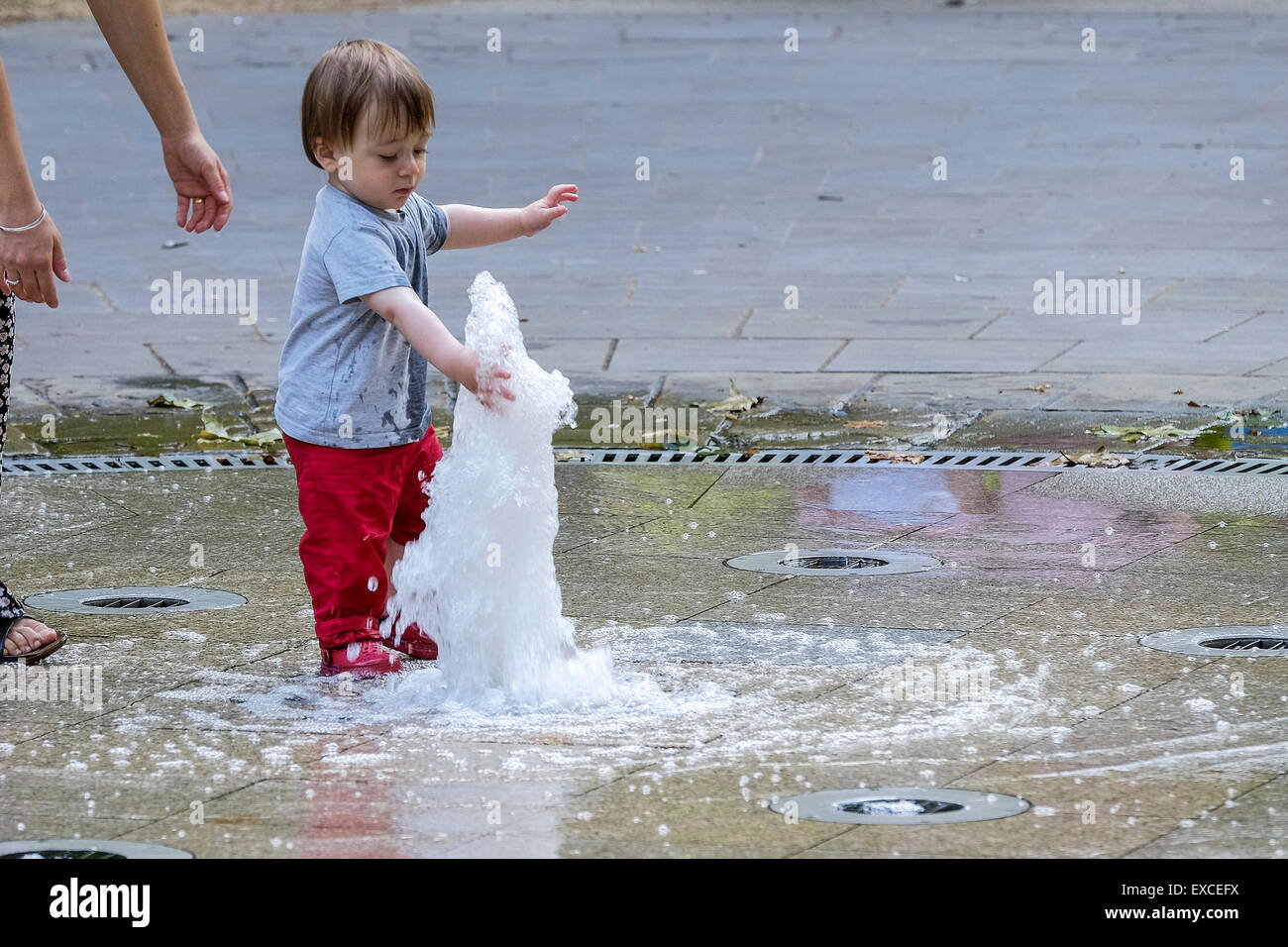 Russell Square Gardens, London, UK. 11. Juli 2015.    Ein Kleinkind entweicht die Wärme in London heute durch Abkühlung in den Brunnen in Russell Sqauare Gärten.  Bildnachweis: Gordon Scammell/Alamy Live-Nachrichten. Stockfoto