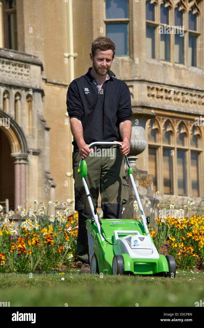 Gärtner Joel Bunting Mähen die Rasen Grenzen im Tyntesfield House Garden, mit schnurlosen mowers.a UK Mähen schneiden Gartenarbeit NT Stockfoto