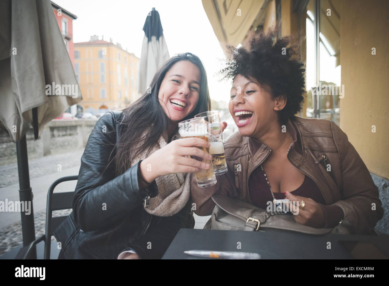 zwei multiethnischen schöne junge Frau Schwarz und kaukasischen Spaß trinken ein Bier in der Stadt Stockfoto