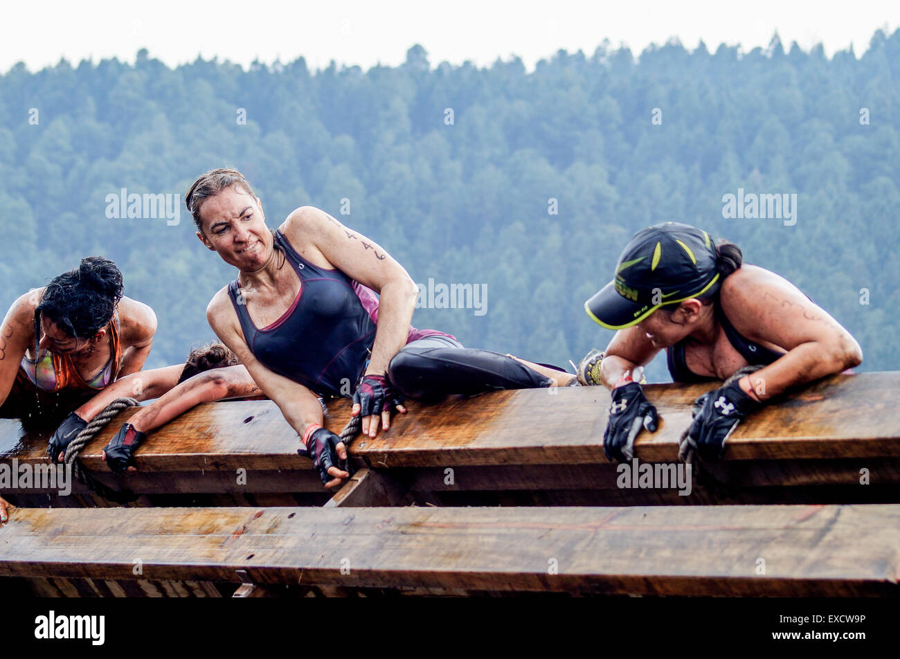 Vier weibliche Athleten Klettern eine Holzrampe auf eine Hölle laufen während des Rennens Crossfit. Stockfoto