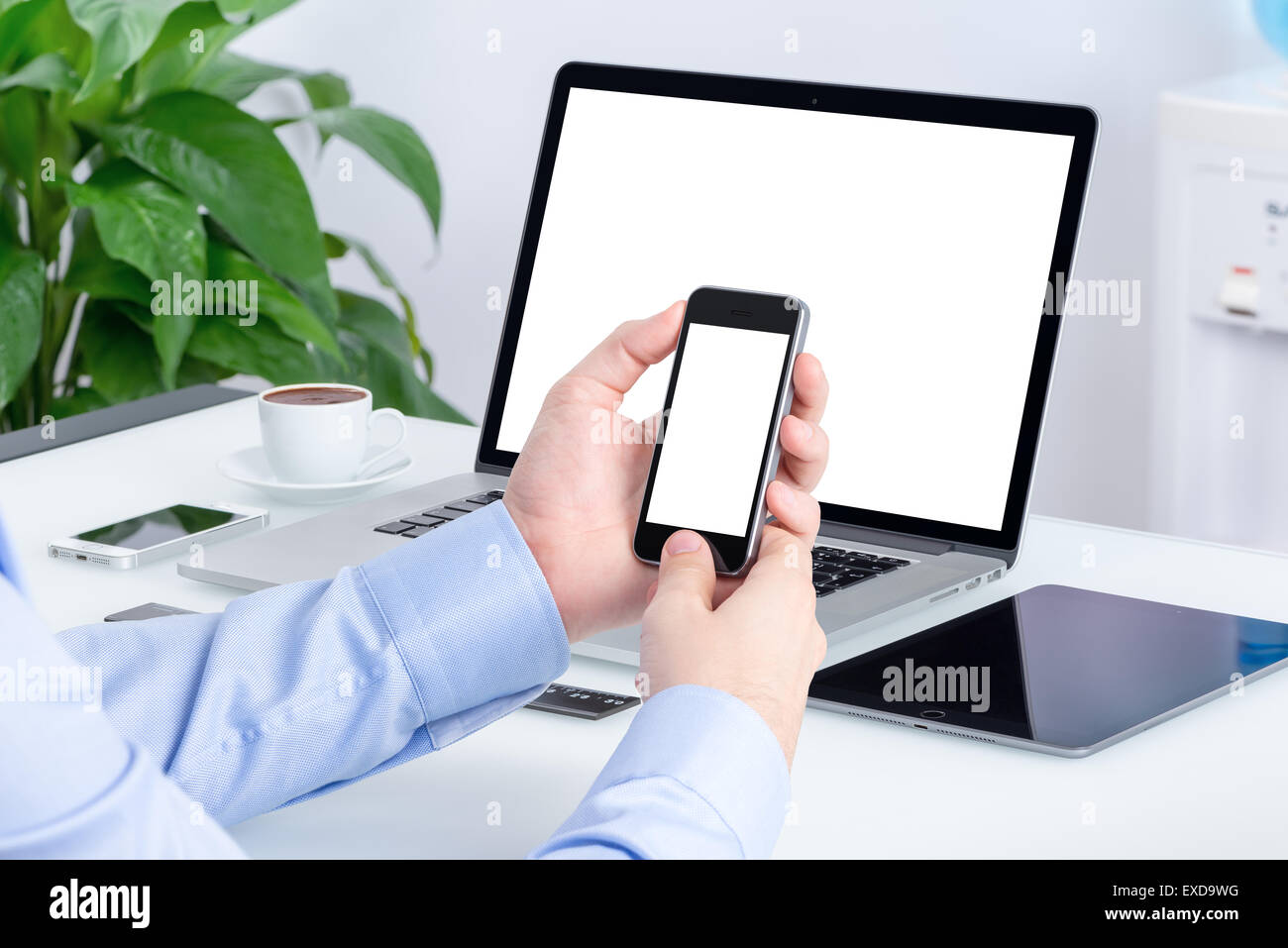 Männliche Hände mit Smartphone-Modell mit leeren Bildschirm an den Schreibtisch mit einer offenen Laptop Mockup und Tablet-Computer. Stockfoto