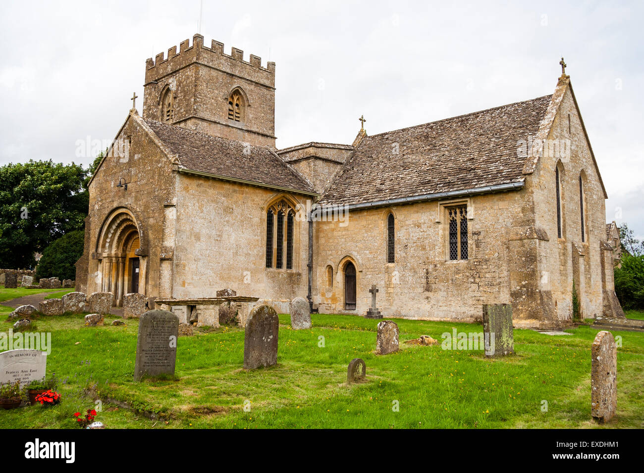 Der Kalkstein Norman St. Michael und alle Engel Kirche und Friedhof in der englischen Dorf Guiting macht. Der Turm ist aus dem 15. Jahrhundert. Stockfoto