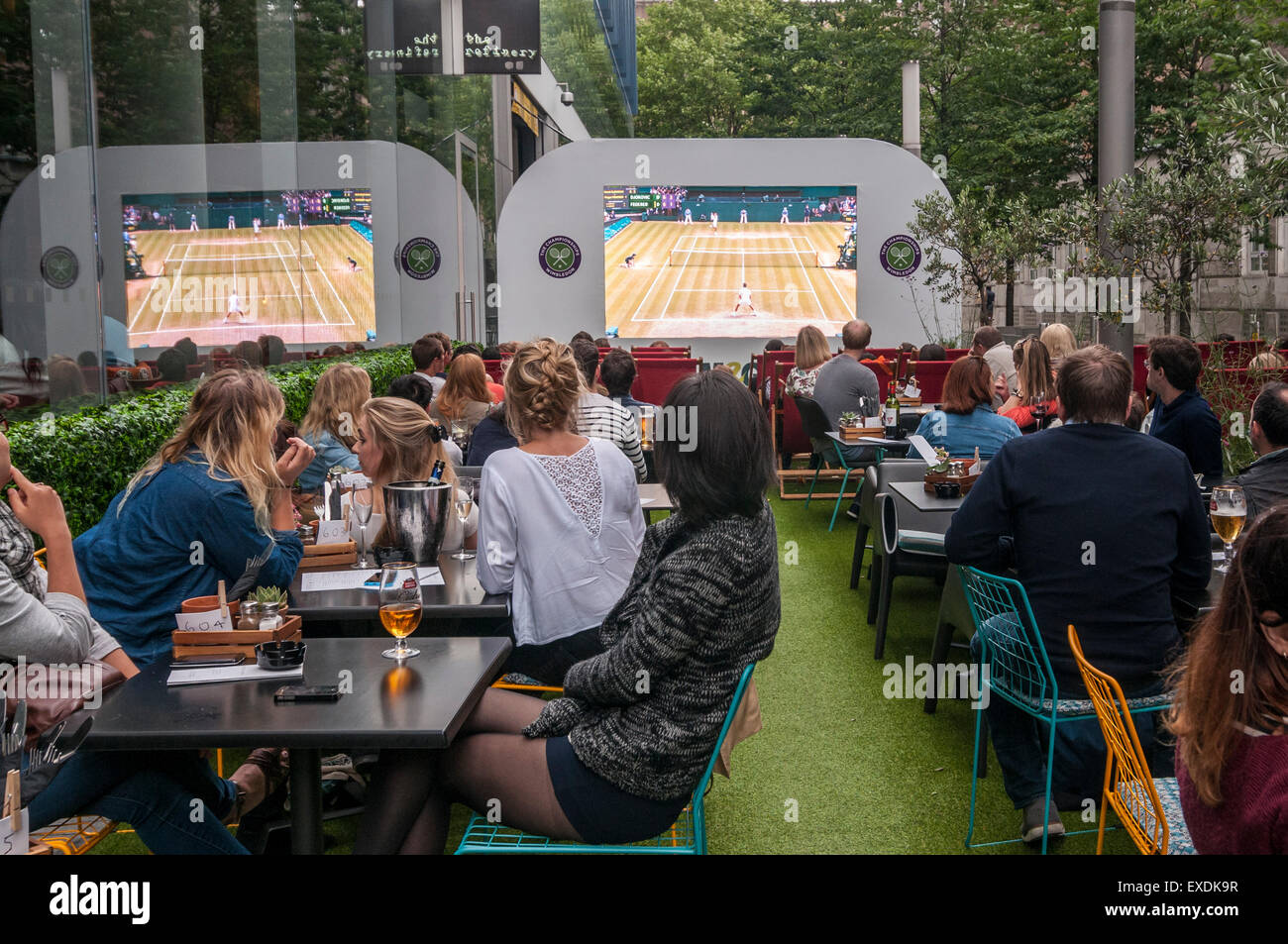 London, UK. 12. Juli 2015. Die Menschen sehen eine Riesenleinwand im Freien, in Bankside Mix in der Nähe von der Tate Modern, zeigt der 2015 Wimbledon Herren-Finale zwischen Novak Djokovic und Roger Federer. Bildnachweis: Stephen Chung / Alamy Live News Stockfoto