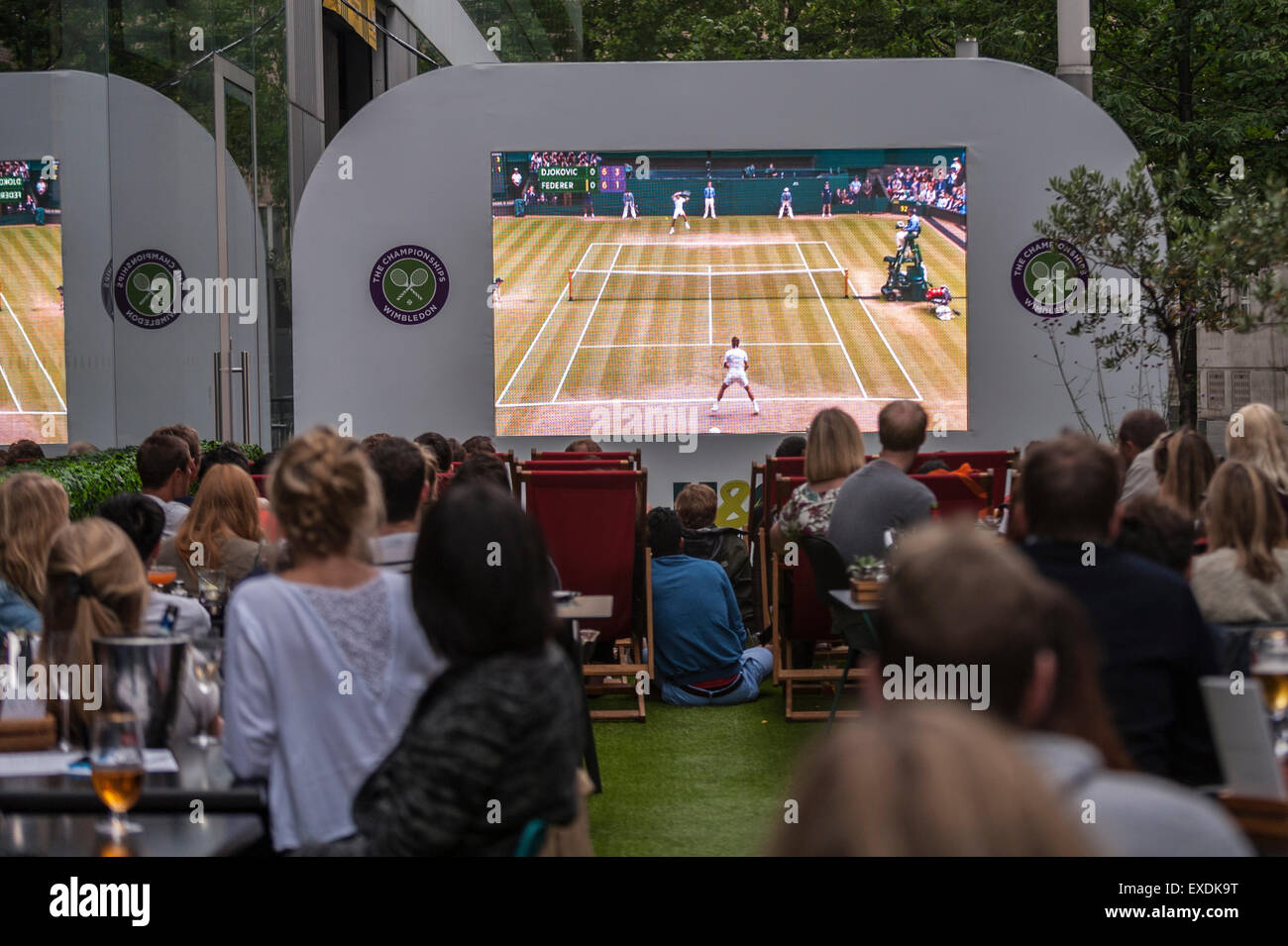 London, UK. 12. Juli 2015. Die Menschen sehen eine Riesenleinwand im Freien, in Bankside Mix in der Nähe von der Tate Modern, zeigt der 2015 Wimbledon Herren-Finale zwischen Novak Djokovic und Roger Federer. Bildnachweis: Stephen Chung / Alamy Live News Stockfoto