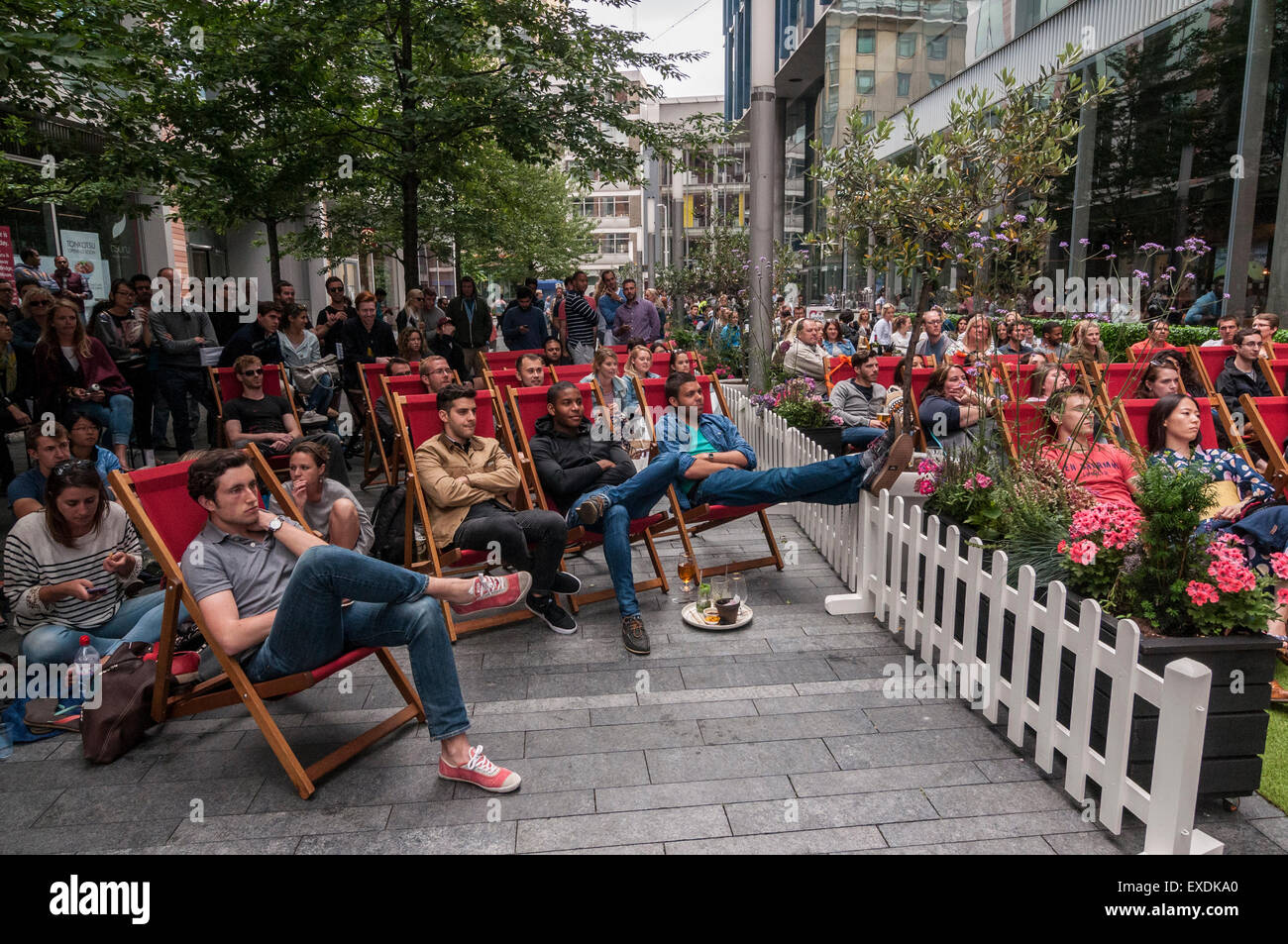 London, UK. 12. Juli 2015. Die Menschen sehen eine Riesenleinwand im Freien, in Bankside Mix in der Nähe von der Tate Modern, zeigt der 2015 Wimbledon Herren-Finale zwischen Novak Djokovic und Roger Federer. Bildnachweis: Stephen Chung / Alamy Live News Stockfoto
