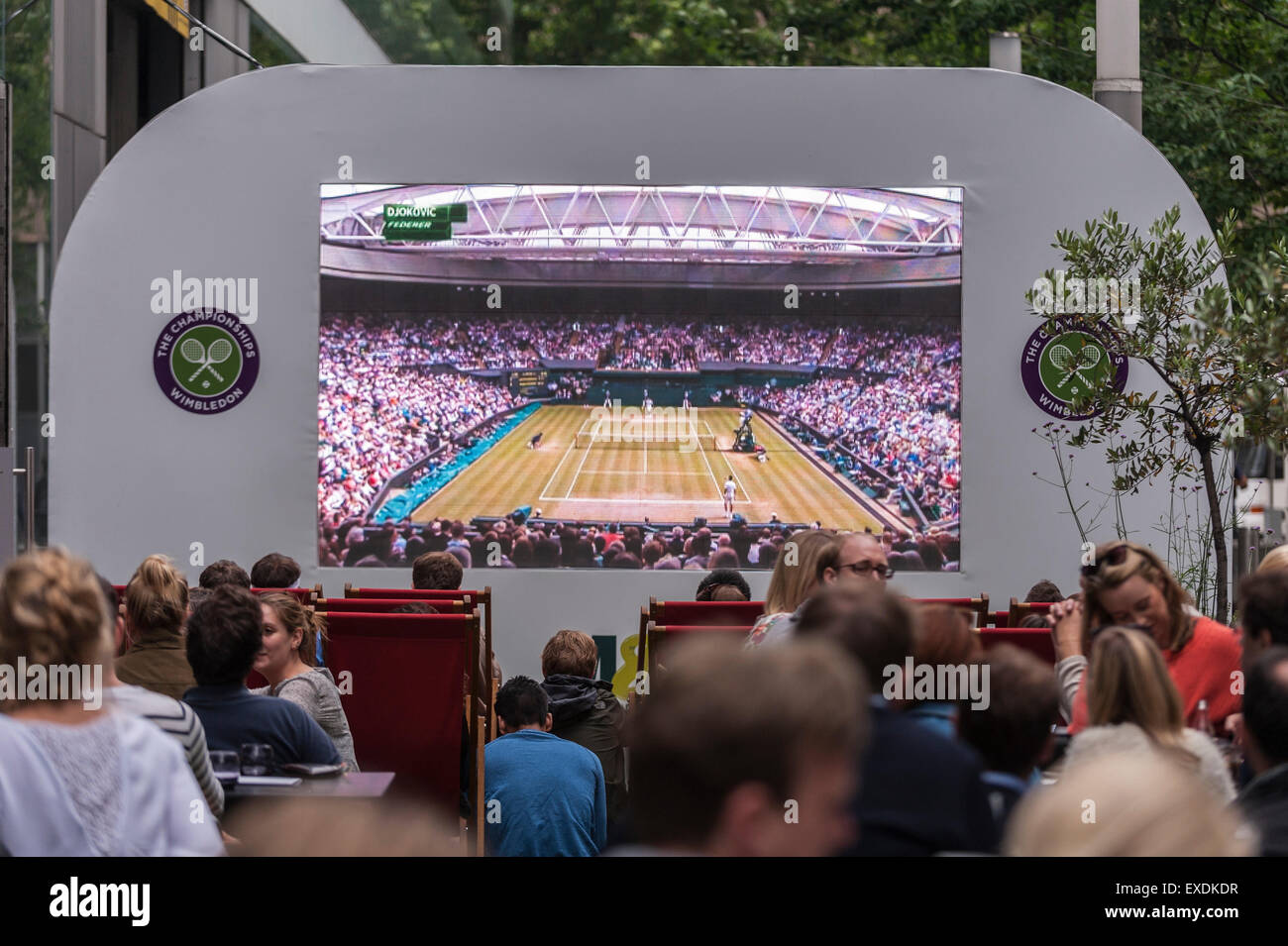 London, UK. 12. Juli 2015. Die Menschen sehen eine Riesenleinwand im Freien, in Bankside Mix in der Nähe von der Tate Modern, zeigt der 2015 Wimbledon Herren-Finale zwischen Novak Djokovic und Roger Federer. Bildnachweis: Stephen Chung / Alamy Live News Stockfoto