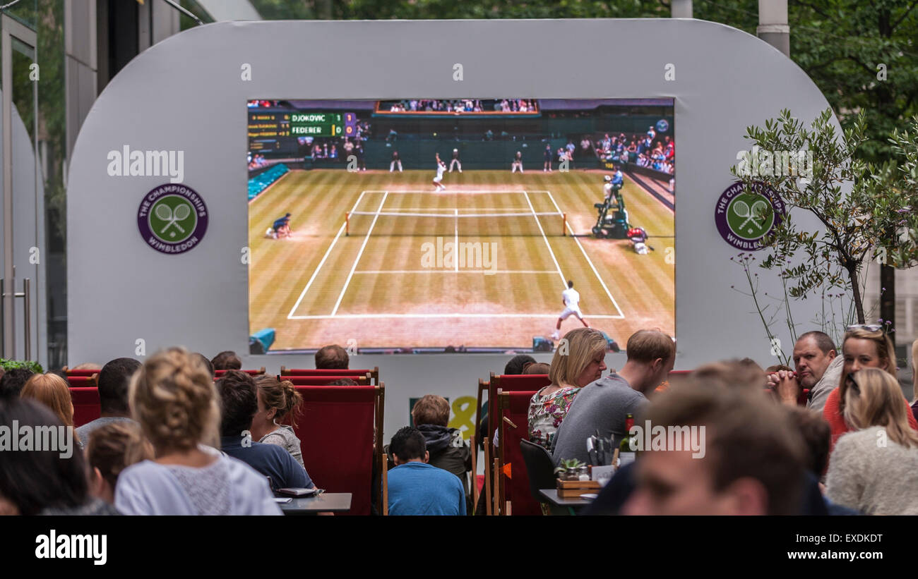 London, UK. 12. Juli 2015. Die Menschen sehen eine Riesenleinwand im Freien, in Bankside Mix in der Nähe von der Tate Modern, zeigt der 2015 Wimbledon Herren-Finale zwischen Novak Djokovic und Roger Federer. Bildnachweis: Stephen Chung / Alamy Live News Stockfoto