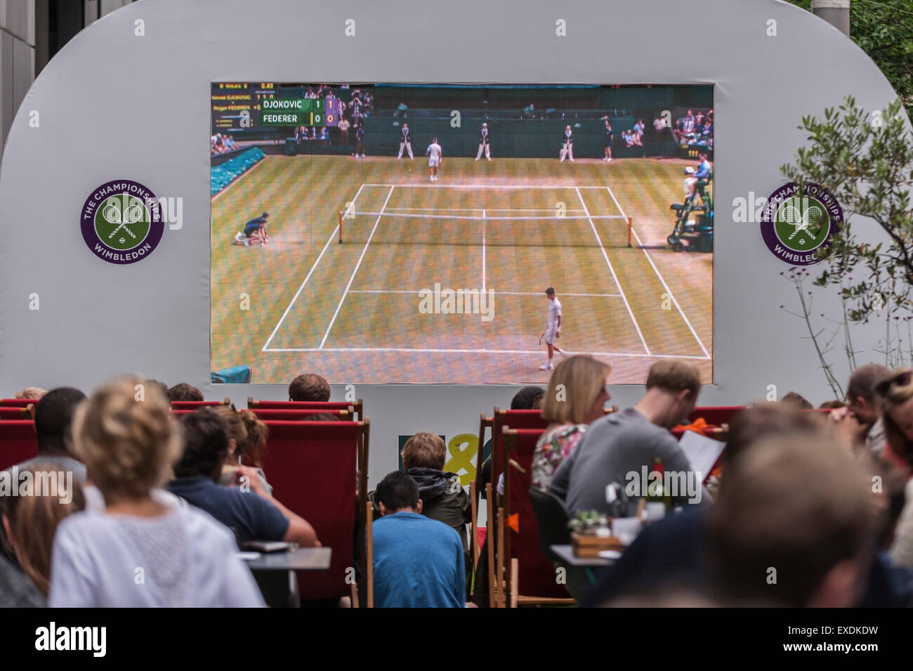 London, UK. 12. Juli 2015. Die Menschen sehen eine Riesenleinwand im Freien, in Bankside Mix in der Nähe von der Tate Modern, zeigt der 2015 Wimbledon Herren-Finale zwischen Novak Djokovic und Roger Federer. Bildnachweis: Stephen Chung / Alamy Live News Stockfoto