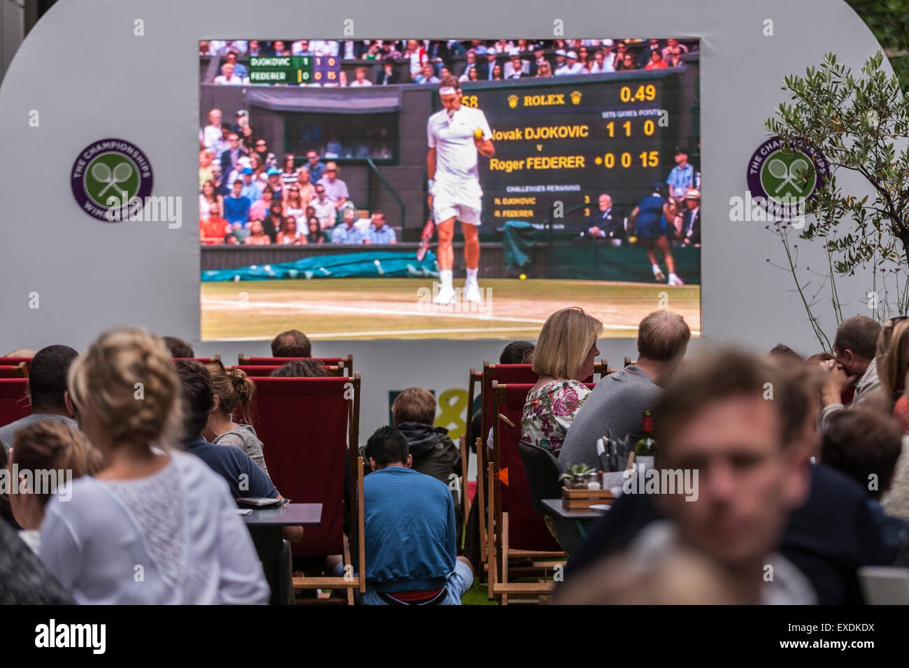 London, UK. 12. Juli 2015. Die Menschen sehen eine Riesenleinwand im Freien, in Bankside Mix in der Nähe von der Tate Modern, zeigt der 2015 Wimbledon Herren-Finale zwischen Novak Djokovic und Roger Federer. Bildnachweis: Stephen Chung / Alamy Live News Stockfoto
