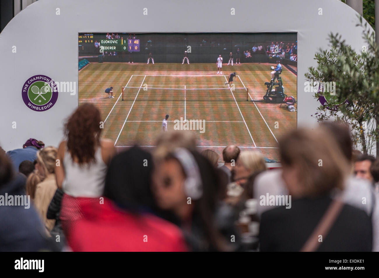 London, UK. 12. Juli 2015. Die Menschen sehen eine Riesenleinwand im Freien, in Bankside Mix in der Nähe von der Tate Modern, zeigt der 2015 Wimbledon Herren-Finale zwischen Novak Djokovic und Roger Federer. Bildnachweis: Stephen Chung / Alamy Live News Stockfoto