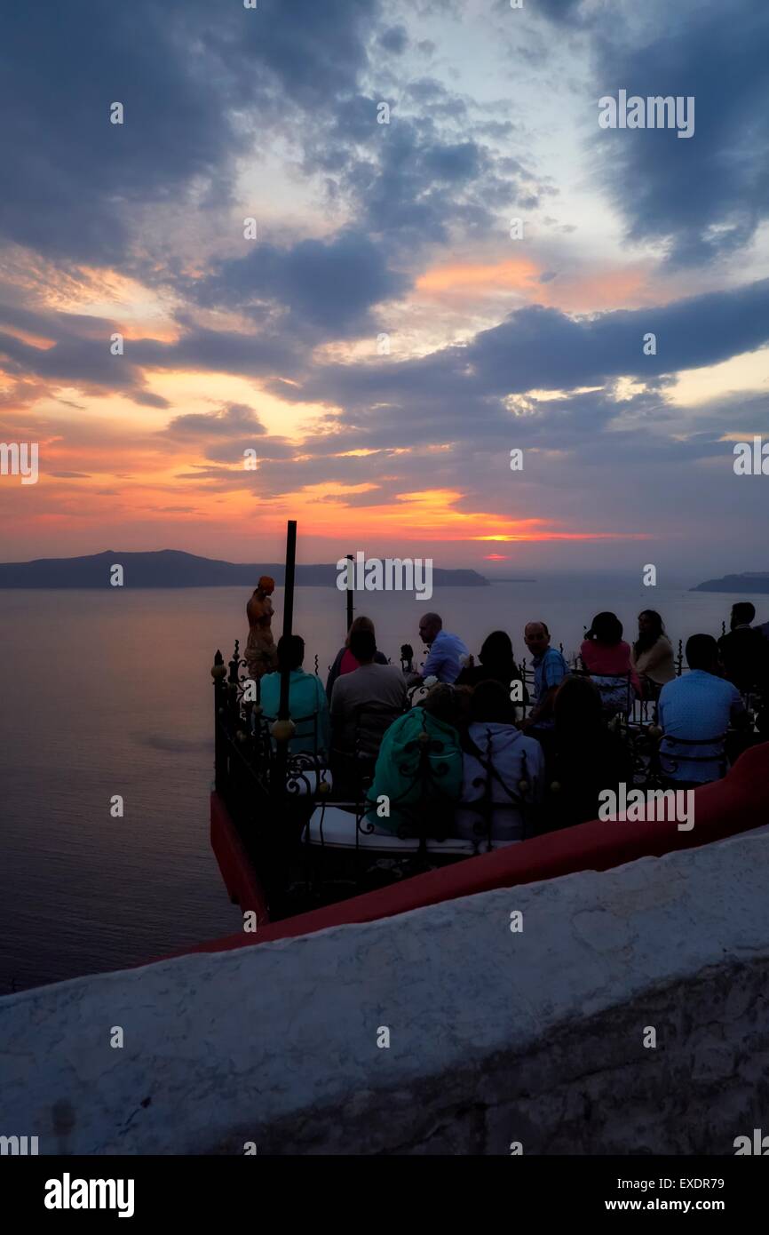 Menschen Essen und trinken in ein Restaurant im Freien während des Sonnenuntergangs in Fira, Santorini, Griechenland. Stockfoto