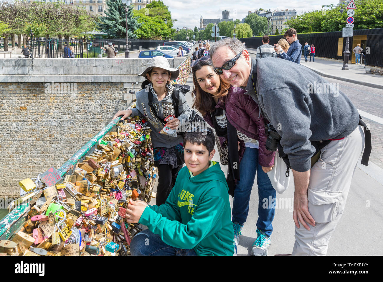Unbekannte Familie sperren eine Liebe Vorhängeschloss an der Brücke Pont de L'Archeveche über das Seineufer in Paris, Frankreich Stockfoto