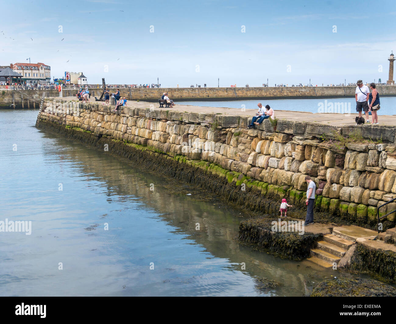 Urlauber auf Tate Hill Pier Whitby North Yorkshire, die Pier erbaute A.D.1190 ist eines der ältesten in der Welt Stockfoto