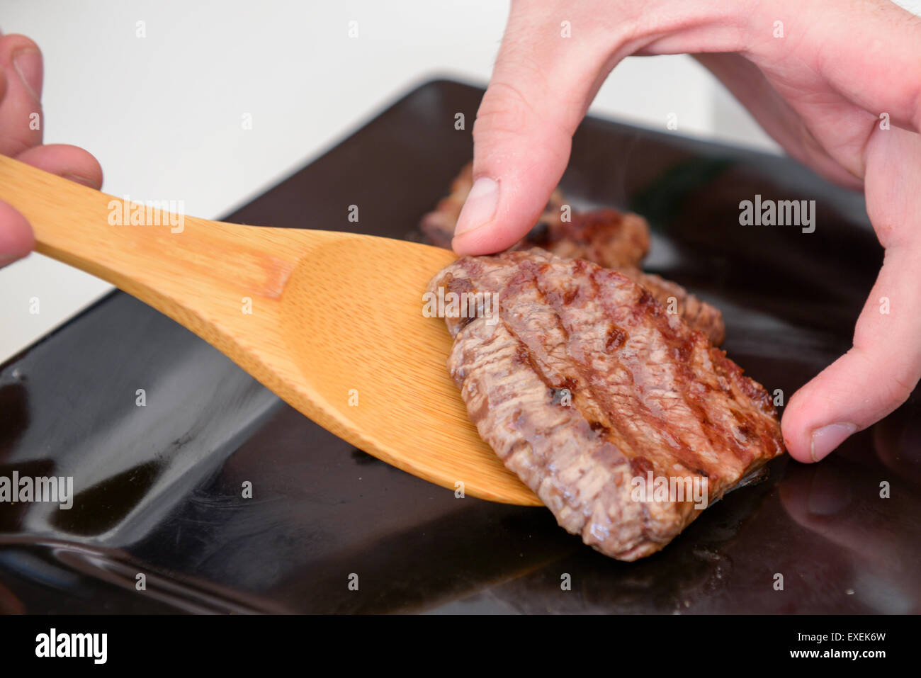 Köstliches saftiges Steak auf einer schwarzen quadratischen Platte Stockfoto