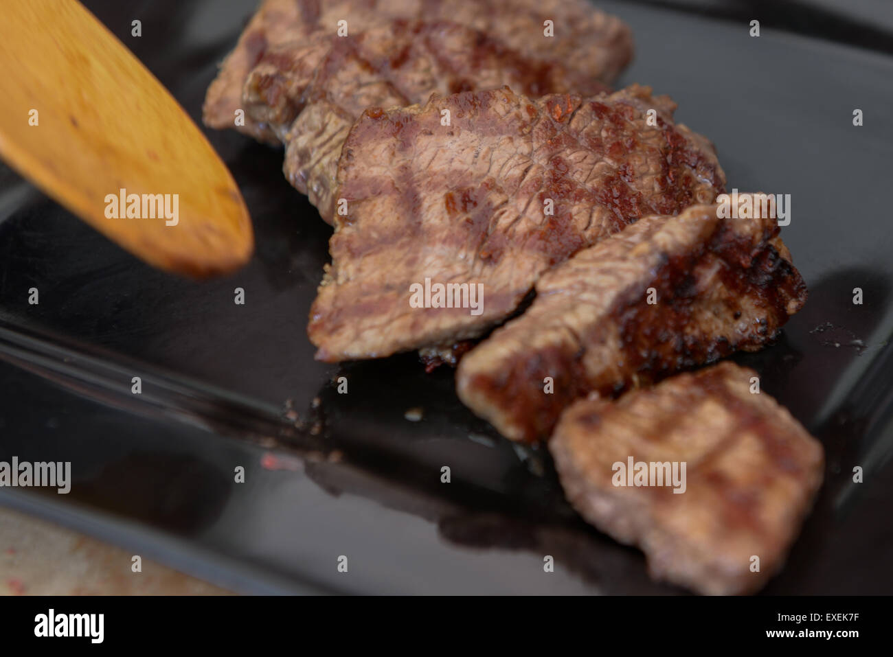 Köstliches saftiges Steak auf einer schwarzen quadratischen Platte Stockfoto