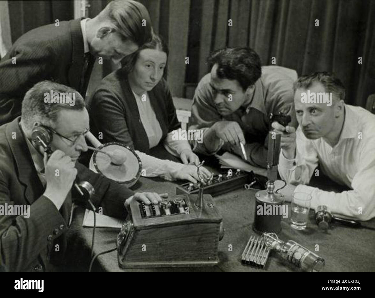 Dieses Bild zeigt die Aufnahme eines Radiospiels, der einen Moment in der Produktion einer Audioperformance festlegt. Hörspiele waren vor Fernsehen und Film ein wichtiges Unterhaltungs-Medium, das sich auf Sound verließ, um Geschichten zu erzählen und den Zuhörern ein immersives Erlebnis zu bieten. Stockfoto