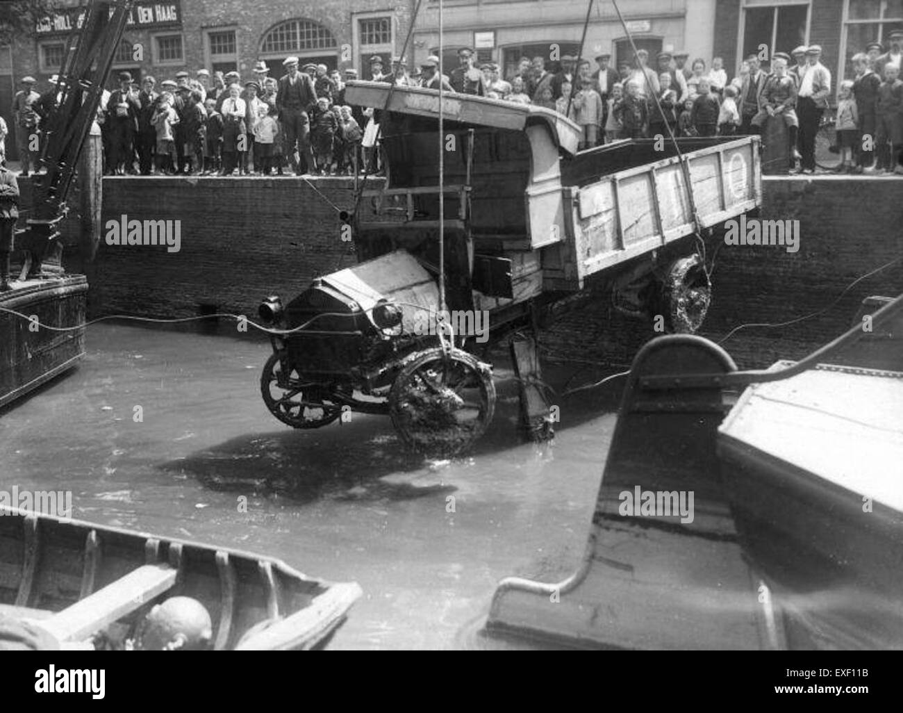 Ein Lkw, der aus einem Kanal gehoben wird, in einem dramatischen Moment gefangen. Diese Szene zeigt die Herausforderungen des städtischen Verkehrs in Umgebungen mit Wasserstraßen und des Einsatzes von Kränen im Schwerlastbetrieb. Stockfoto