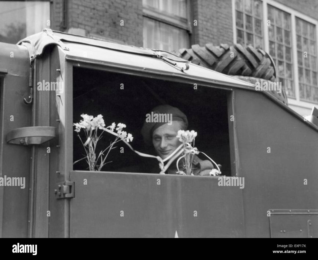 Dieses Kunstwerk mit dem Titel „Bloemen voor militair in pantservoertuig“ zeigt einen Soldaten, der an Bord eines gepanzerten Fahrzeugs Blumen empfängt, was den Kontrast zwischen Krieg und Frieden in einem militärischen Kontext symbolisiert. Stockfoto