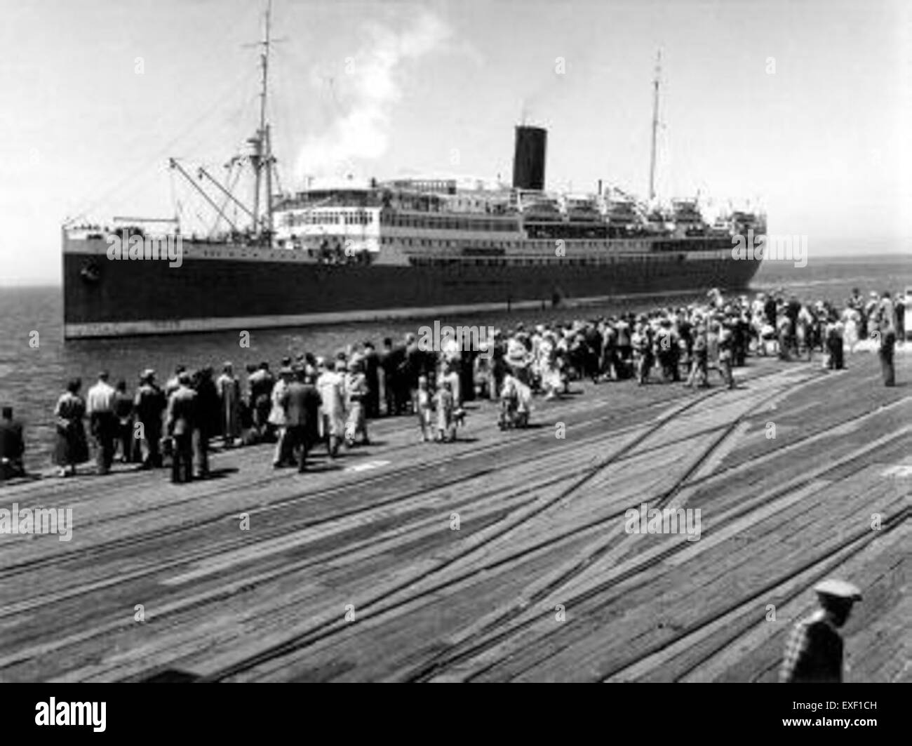 Dieses Gemälde mit dem Titel „Ankunft des Schiffs mit Emigranten in Australien“ zeigt den Moment, als europäische Einwanderer erstmals in Australien ankamen, und erfasst die frühe Geschichte der Migration im 19. Jahrhundert. Stockfoto