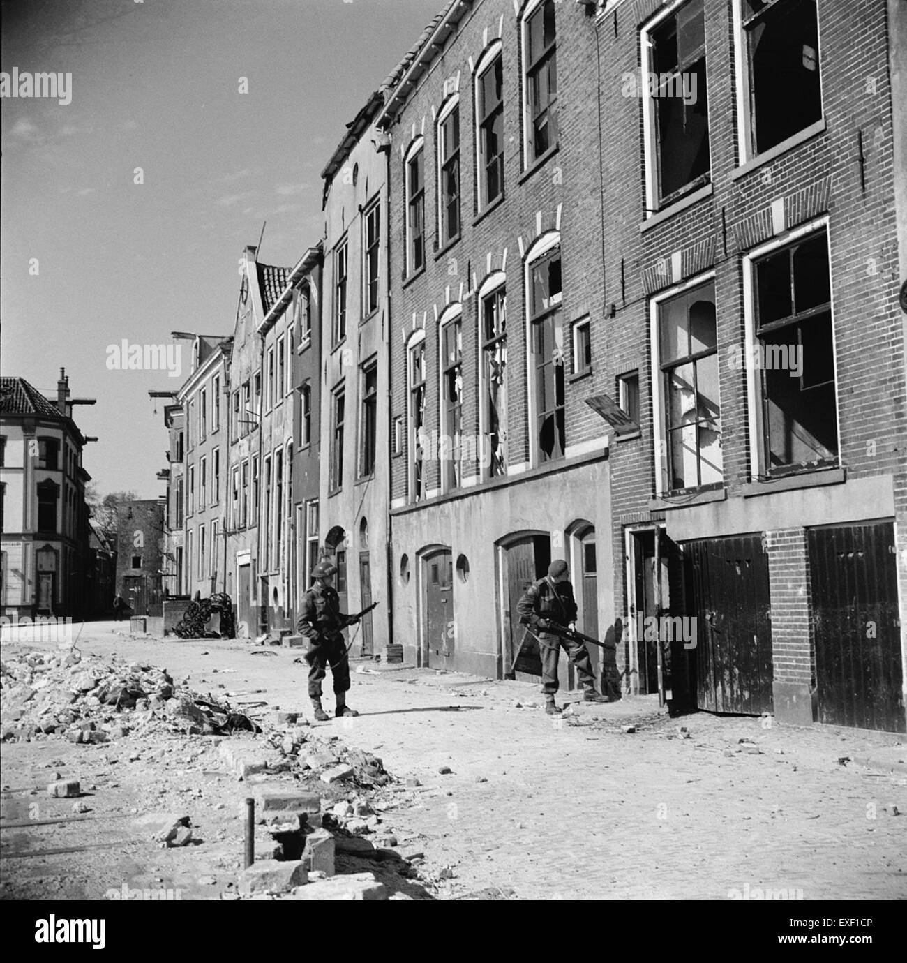 Dieses historische Foto zeigt kanadische Soldaten, die während der Befreiung der Stadt im Zweiten Weltkrieg das Stadtzentrum von Deventer, Niederlande, durchsuchten. Das Bild zeigt die Bemühungen der Alliierten, die niederländischen Städte 1945 von der deutschen Besatzung zu befreien. Stockfoto