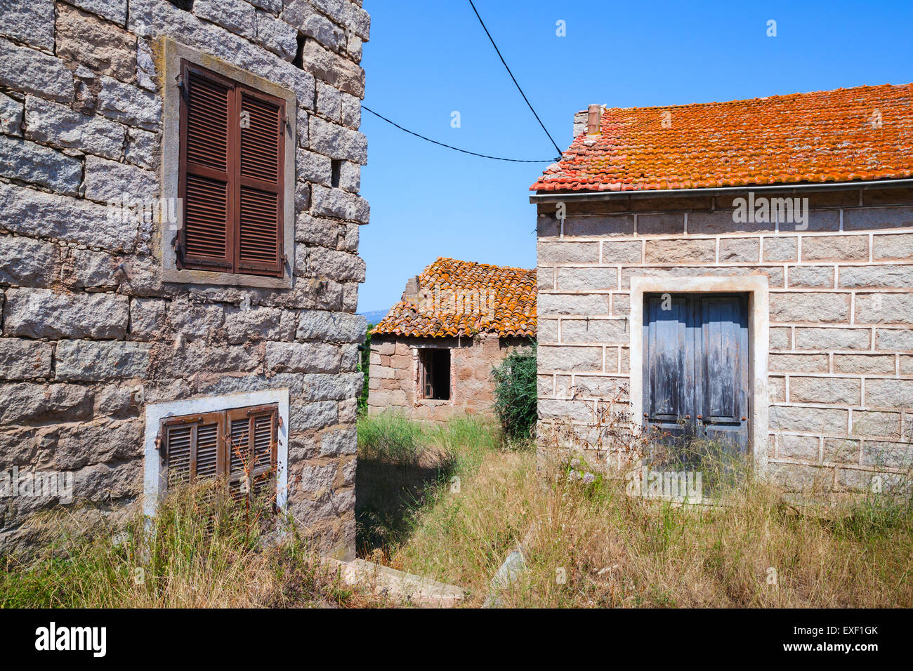 Figari Süd-Korsika, ländliche Architektur Beispiel. Alte Wohnhäuser aus Steinen mit roten Ziegeldächern, Holztüren und Fenster gemacht Stockfoto