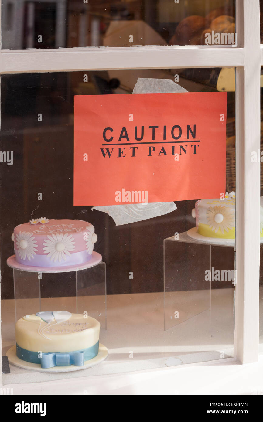 Vorsicht nasse Farbe auf Fenster von Cake Shop in Gosport, Hampshire, UK im Juli klemmt Stockfoto