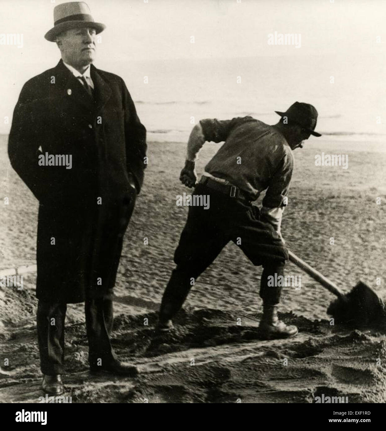 Dieses Kunstwerk, Diktator naast spittende arbeider, veranschaulicht den Kontrast zwischen Macht und Arbeit. Das Stück reflektiert soziale Themen und hebt die Diskrepanz zwischen Autorität und ArbeiterInnenklasse hervor. Stockfoto