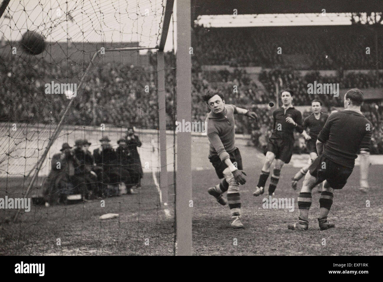 Dieser Moment des Spiels 1934 zwischen den Niederlanden und Belgien zeigt, dass die niederländische Mannschaft ein Tor erzielt und einen wichtigen Moment in der Fußballgeschichte festgehalten hat. Das Bild spiegelt die ersten Jahre des internationalen Fußballwettbewerbs wider. Stockfoto