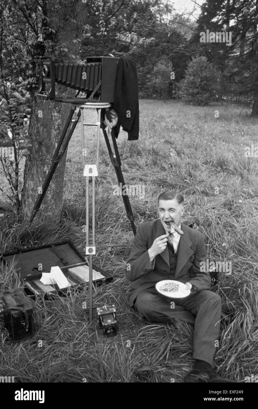 Ein humorvolles Bild eines Fotografen, der „boerenkool met Worst“ isst, ein traditionelles holländisches Gericht aus Grünkohl und Wurst. Das Foto reflektiert die niederländische kulturelle Küche und das tägliche Leben der Zeit, in einem offenen Moment festgehalten. Stockfoto