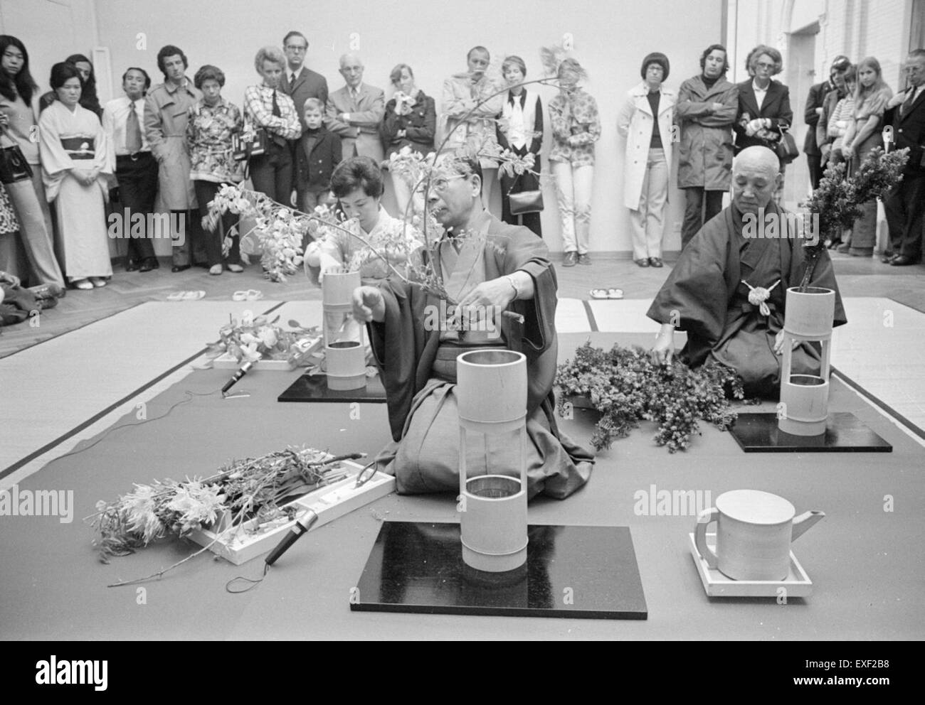 Dieses Bild zeigt japanische Blumenarrangierer, die Ikebana praktizieren, die traditionelle japanische Kunst des Blumenarrangierens. Im Mittelpunkt stehen Balance, Harmonie und Einfachheit, wesentliche Prinzipien dieser disziplinierten Kunstform. Stockfoto