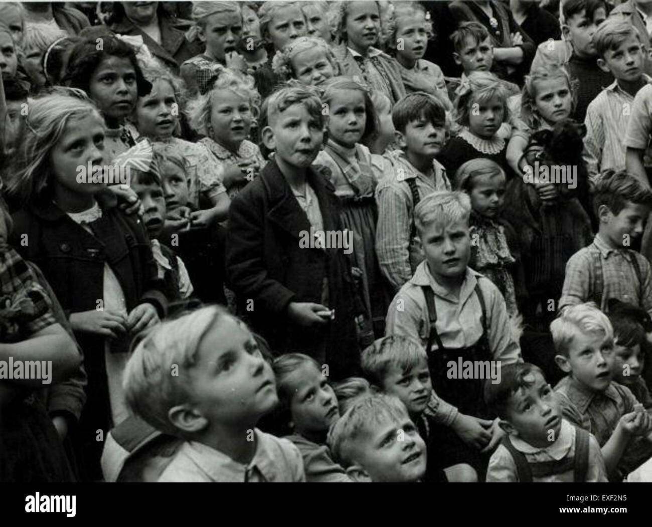 Dieses historische Bild fängt Kinder während der Feierlichkeiten rund um die Einweihung der Königin Juliana von den Niederlanden ein. Die Szene spiegelt die festliche Atmosphäre und die Bedeutung des Ereignisses in der niederländischen Geschichte wider. Stockfoto