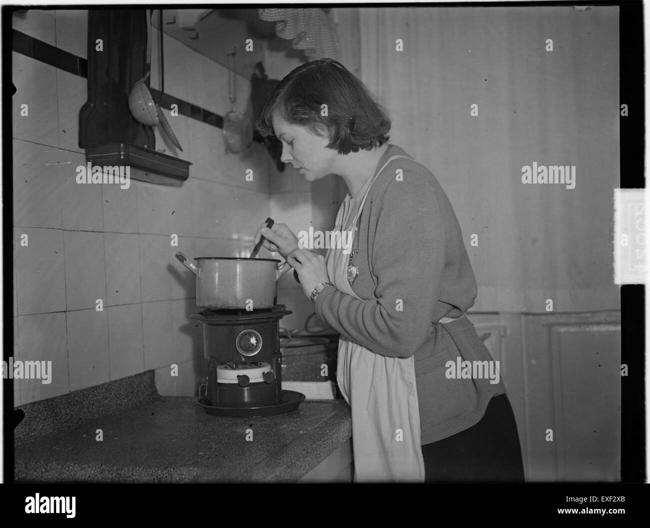 Dieses historische Bild zeigt das Kochen auf einem Petroleumofen und bietet einen Einblick in die Verwendung alternativer Brennstoffe im 19. Und frühen 20. Jahrhundert. Petroleumöfen waren eine beliebte Wahl für effizientes Kochen in dieser Zeit. Stockfoto