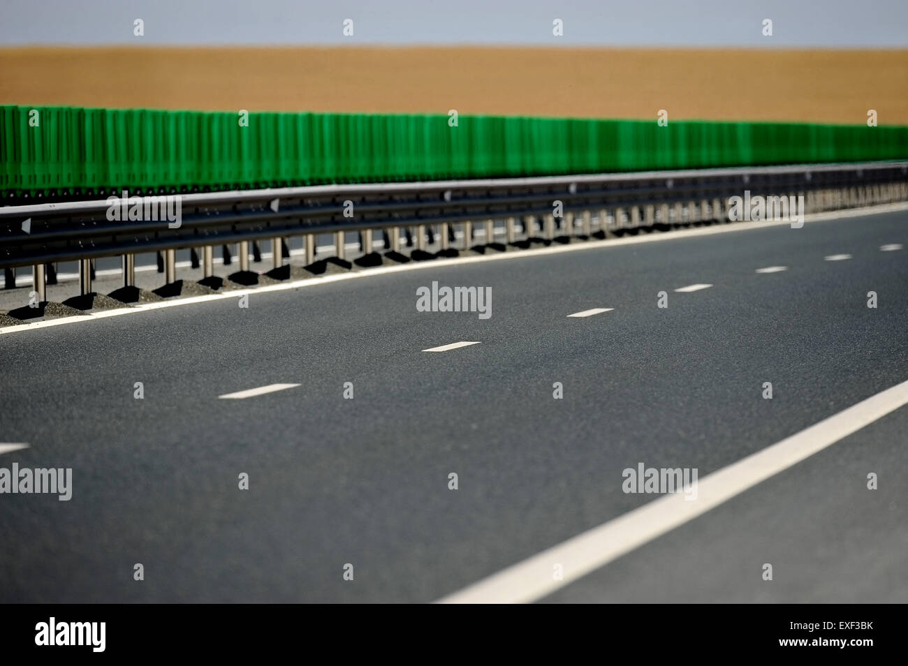 Leere zwei-spurige Autobahn mit Weizenfeld auf dem Hintergrund Stockfoto