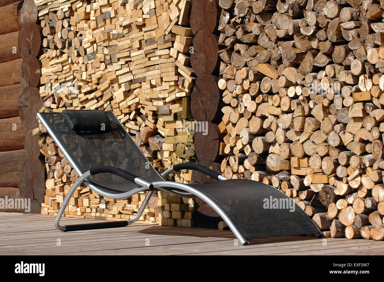 Liegestuhl auf der Terrasse mit Holzstapel Hintergrund Stockfotografie -  Alamy