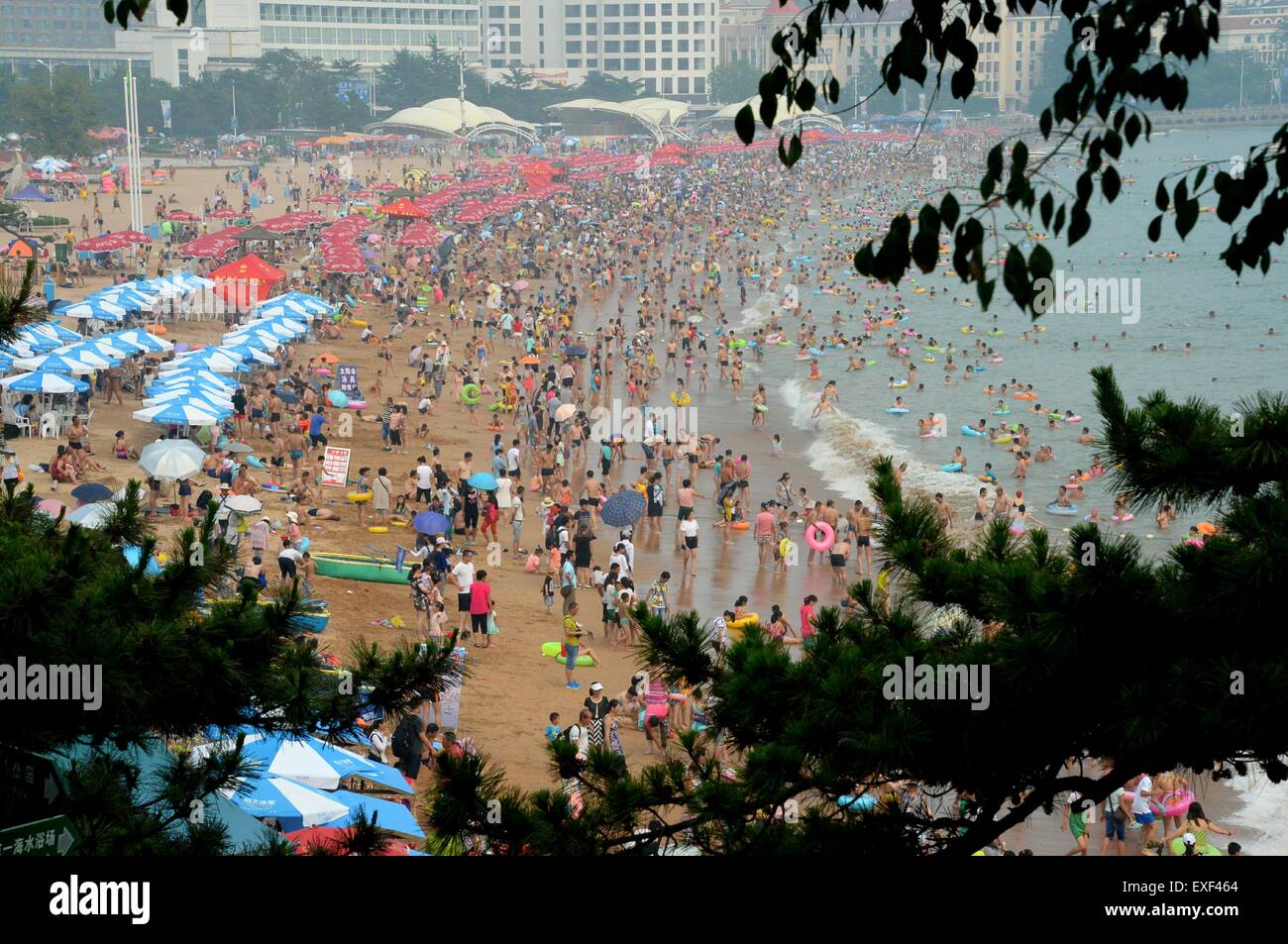 Qingdao, China Shandong Provinz. 13. Juli 2015. Die Menschen versammeln sich an einem Strand in Qingdao, der ostchinesischen Provinz Shandong, 13. Juli 2015. Strände in Qingdao wurden Schwarm von Menschen in der Hitzewelle, die viele Teile im Nordchinas am Montag getroffen. Bildnachweis: Feng Jie/Xinhua/Alamy Live-Nachrichten Stockfoto