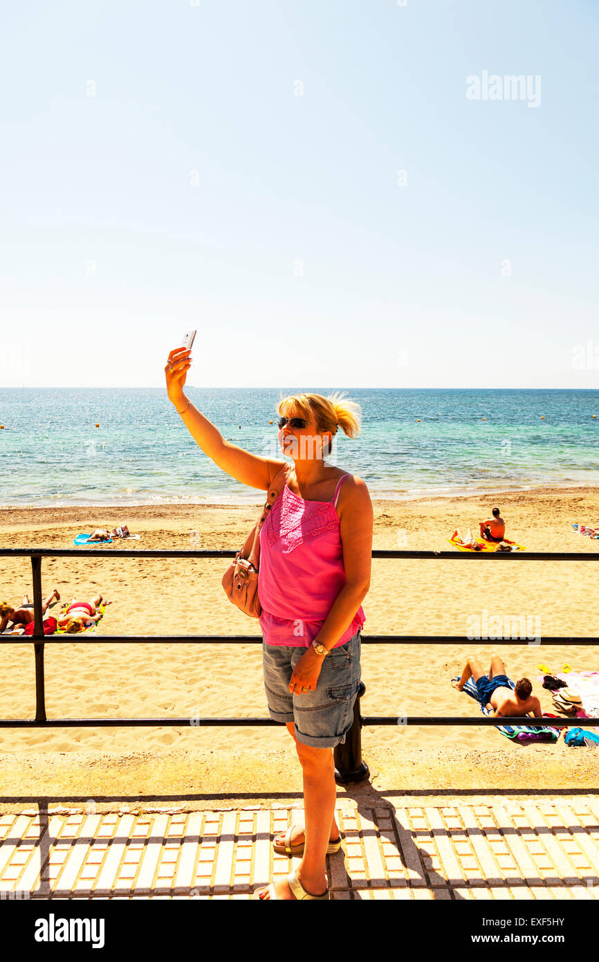 Die Selfie nahe Strand auf Urlaub Frau Dame auf Urlaub Meer Sand Handy-Benutzer verwendet Stockfoto