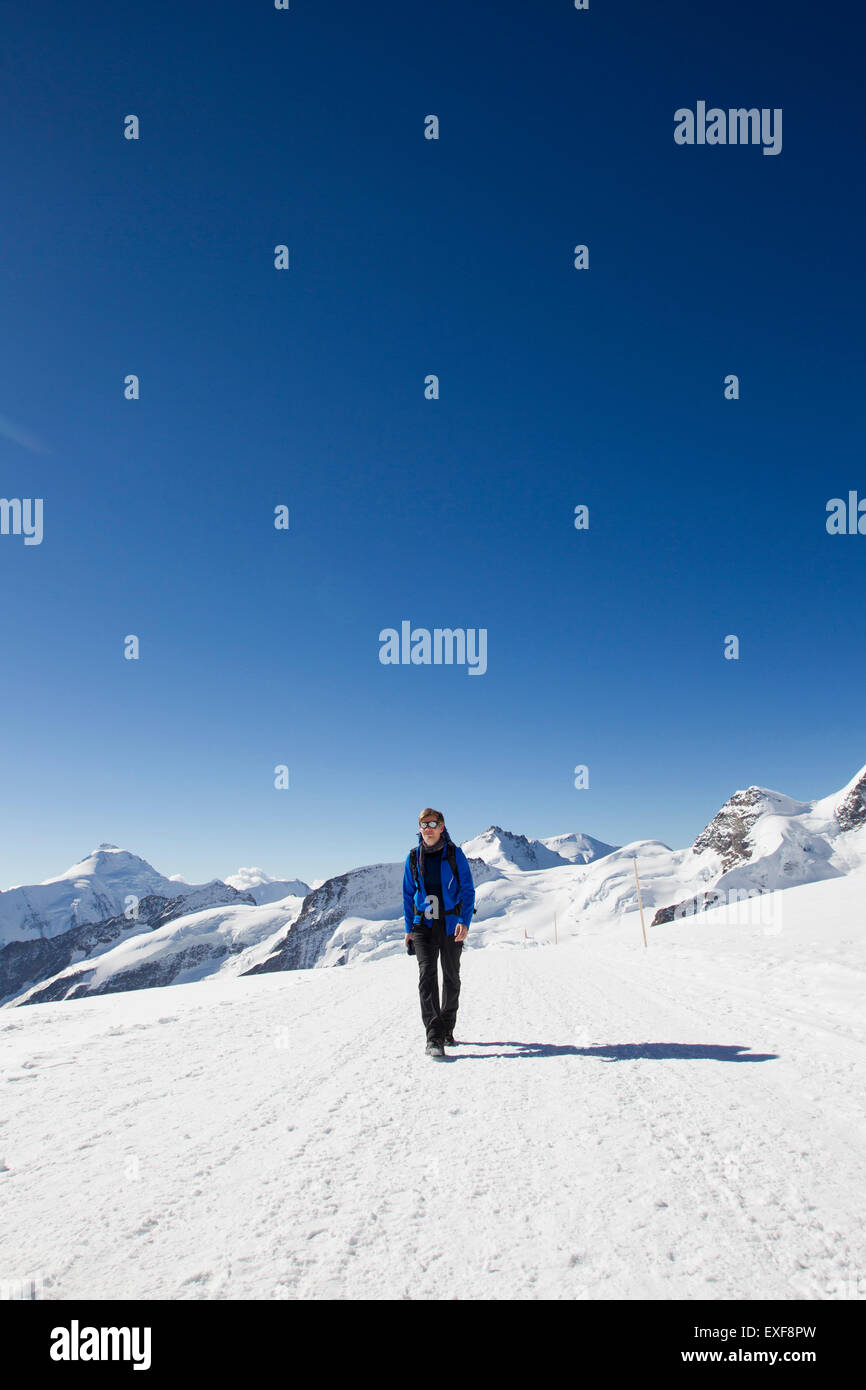 Männliche Wanderer Wandern im Schnee bedeckt Landschaft, Jungfrauchjoch, Grindelwald, Schweiz Stockfoto