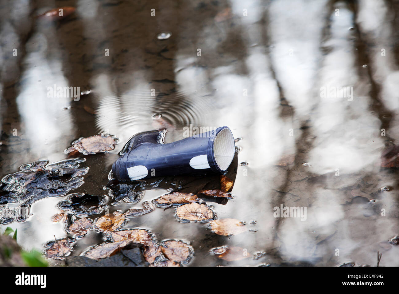 Einsamer Wellington Boot im Wasser Stockfoto