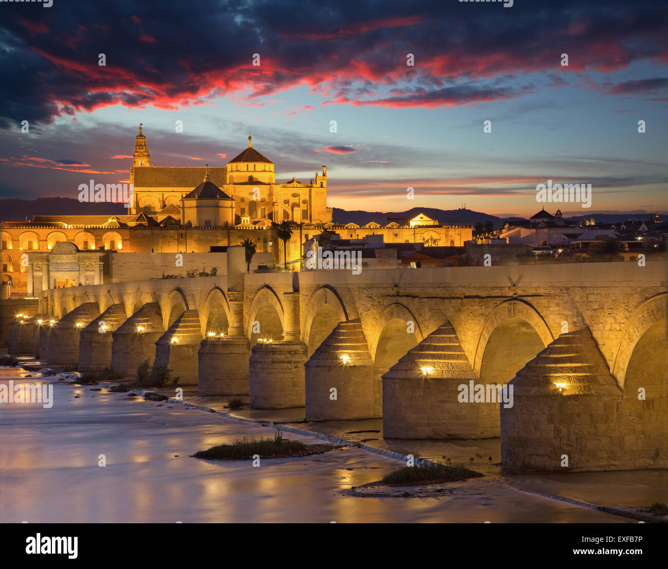 Cordoba - die römische Brücke und die Kathedrale im Hintergrund in der Abenddämmerung Stockfoto
