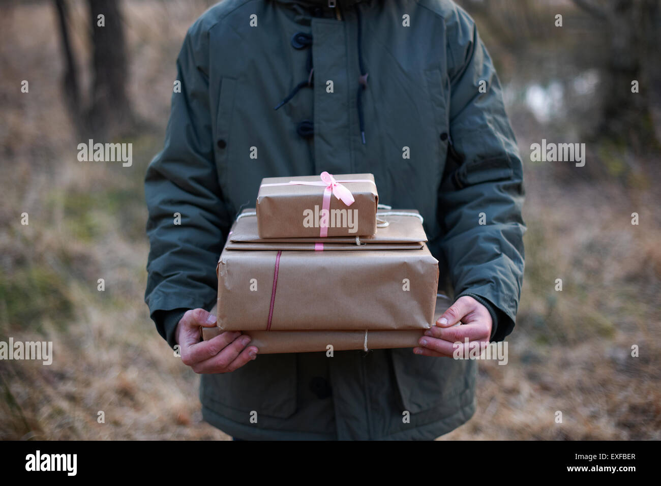 Schuss von Geschenken durch Wald von junger Mann getragen werden abgeschnitten Stockfoto