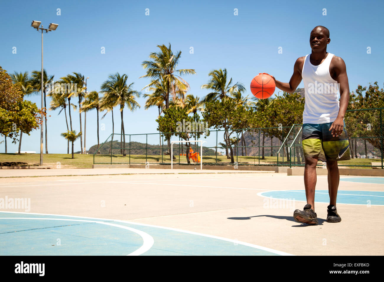 Junger Mann üben Basketball am Basketballplatz Stockfoto