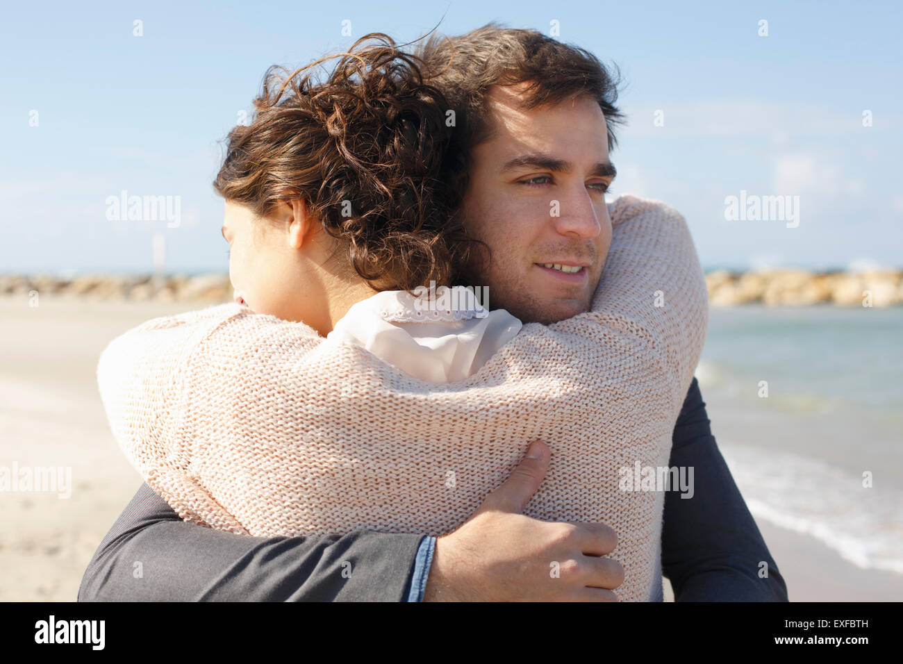 Junges Paar umarmt einander am Strand, Tel Aviv, Israel Stockfoto