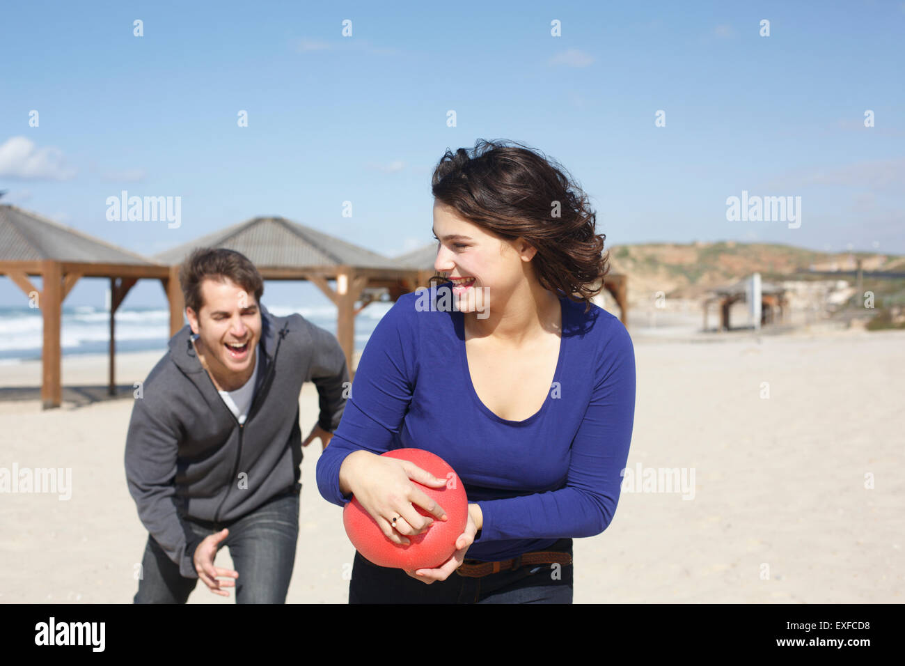 Junges Paar laufen mit Ball am Strand, Tel Aviv, Israel Stockfoto