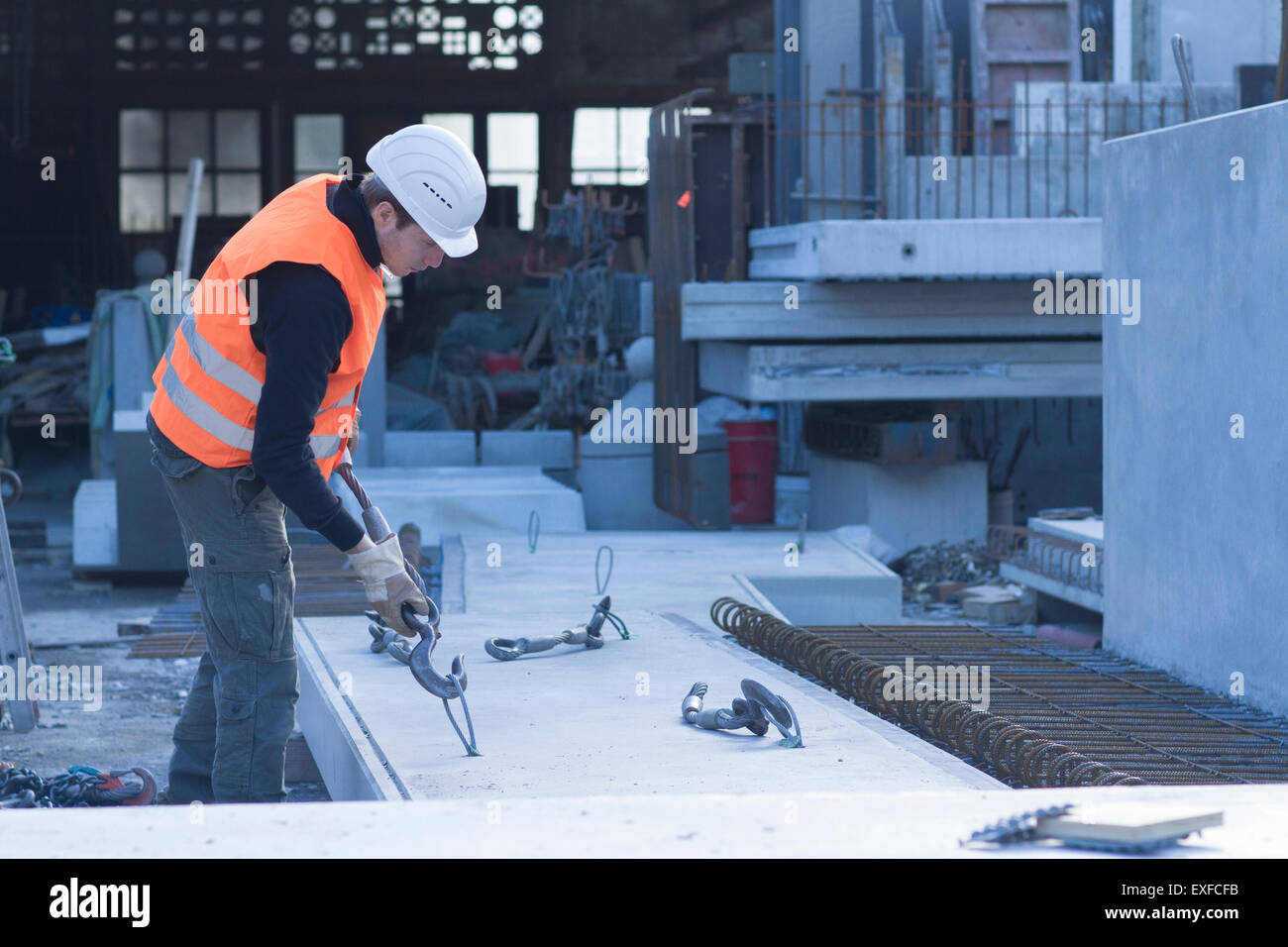 Fabrik Arbeiter anbringen Winde Haken zu Betonklotz in Betonverstärkungen Fabrik Stockfoto