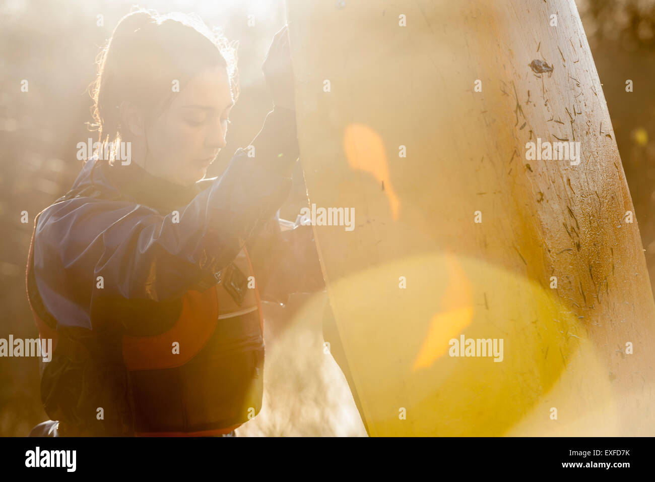 Junge Frau mit Kanu im Sonnenlicht Stockfoto