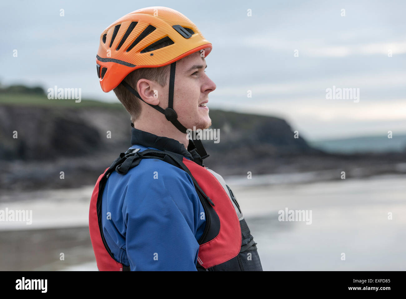 Junger Mann mit Helm und Schwimmweste Stockfoto