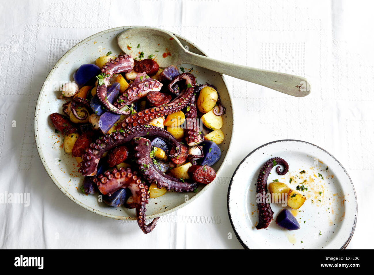 Schüssel mit Tintenfisch Tentakeln und Kartoffeln Stockfoto